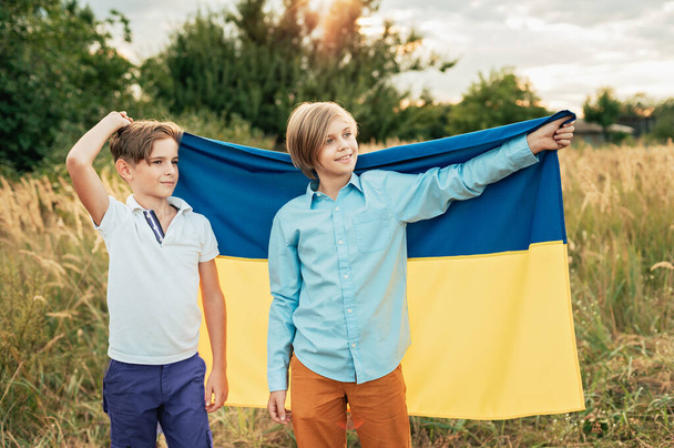 Ukraines Independence Flag Day. Constitution day. Ukrainian child boy in shirt with yellow and blue flag of Ukraine in field. - Foto, Bild