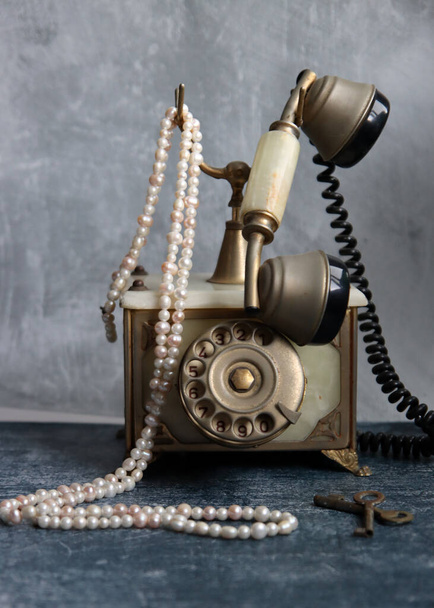 Παλιομοδίτικο περιστροφικό τηλέφωνο σε ένα τραπέζι. Vintage τηλέφωνο close up φωτογραφία. Γκρι υφή φόντο με αντίγραφο χώρου. - Φωτογραφία, εικόνα