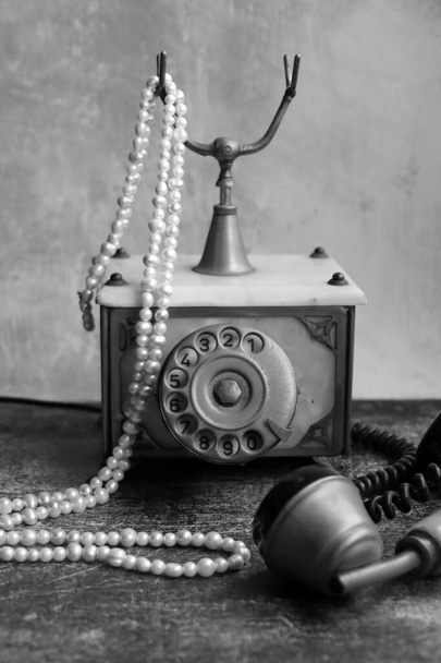 Παλιομοδίτικο περιστροφικό τηλέφωνο σε ένα τραπέζι. Vintage τηλέφωνο close up φωτογραφία. Γκρι υφή φόντο με αντίγραφο χώρου. - Φωτογραφία, εικόνα