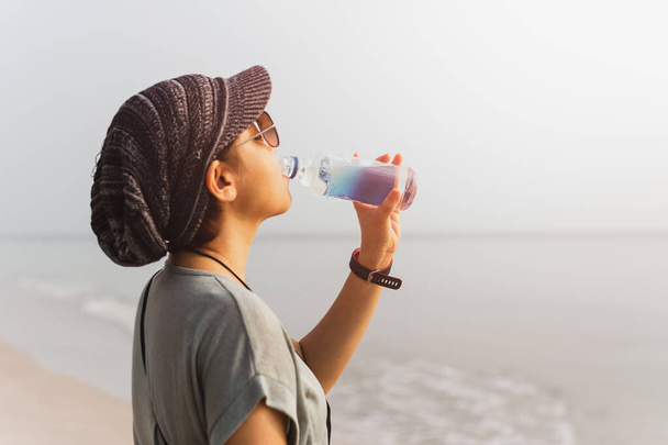 Туристична жінка зволожує питну воду з пляшки
. - Фото, зображення