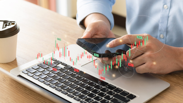 Zakenmensen werken met beleggingen op de aandelenmarkt met behulp van een laptop om handelsgegevens te analyseren. smartphone met beursgrafiek op het scherm. Financiële beurs. - Foto, afbeelding