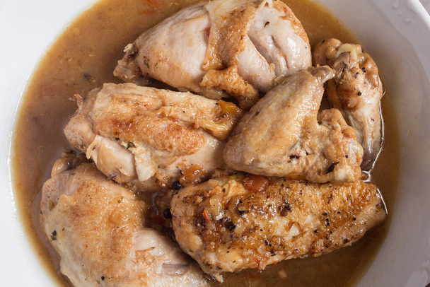 Bovenaanzicht van een plating food van kippenvoer in groentesaus met cognac in een keramische schotel. Recepten van vlees en groenten. - Foto, afbeelding