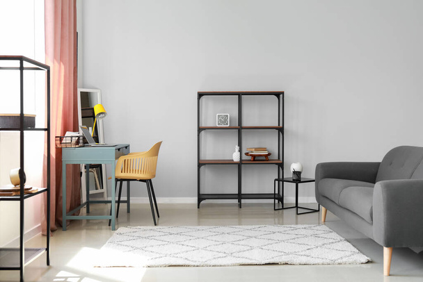 Interior of modern room with shelf unit, workplace and sofa - Photo, Image