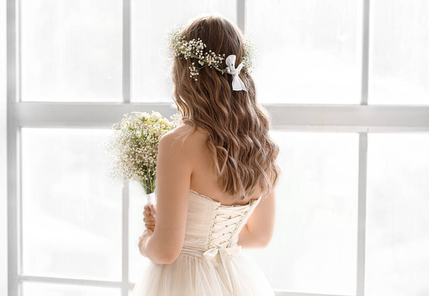 Schöne Braut mit Blumenstrauß am Fenster - Foto, Bild