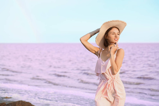 Élégante jeune femme posant près du lac rose le jour de l'été - Photo, image