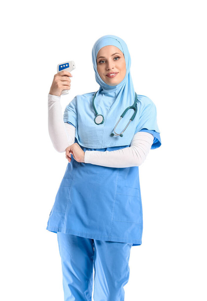 Női muszlim orvos hőmérővel fehér alapon - Fotó, kép