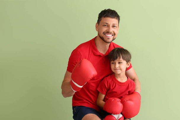 Petit garçon avec entraîneur de boxe sur fond vert - Photo, image