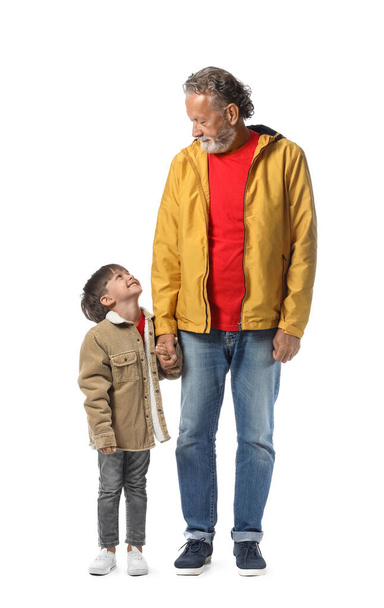 Kisfiú és nagyapja meleg kabátban fehér háttér - Fotó, kép