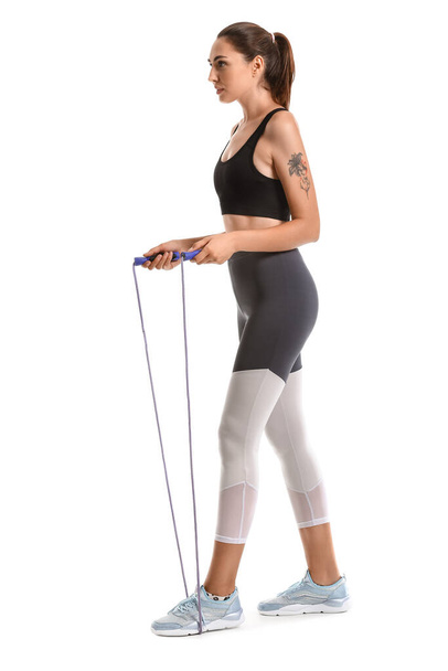 Sporty young woman with skipping rope on white background - Photo, Image