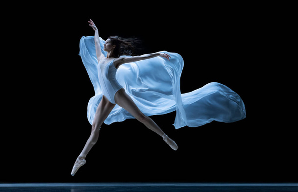 Graceful classic ballerina dancing with weightless fabric isolated on black studio background in neon. Theater, art, beauty, grace, action and motion concept. - Foto, immagini