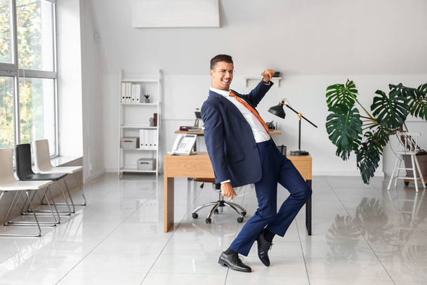 Dancing young businessman in office - Foto, afbeelding