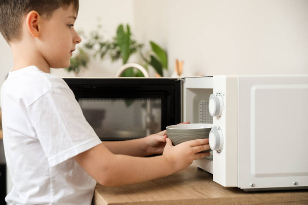 Little boy heating food in microwave oven - 写真・画像