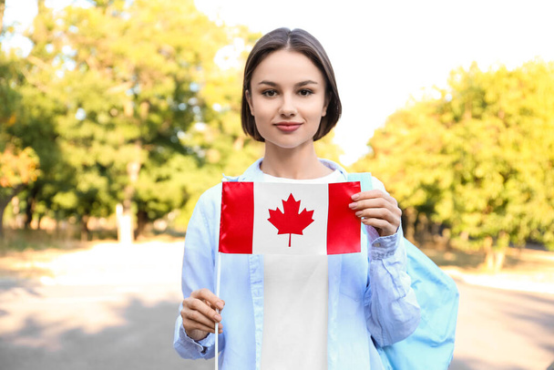 Όμορφη γυναίκα τουρίστρια με σημαία του Καναδά σε εξωτερικούς χώρους - Φωτογραφία, εικόνα