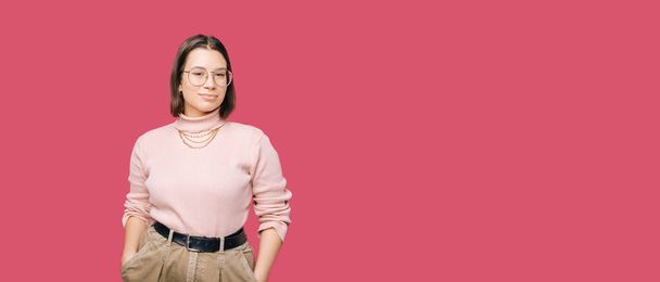 Banner size portrait photo of a young confident woman wearing glasses over pink backdrop. - Foto, Imagen
