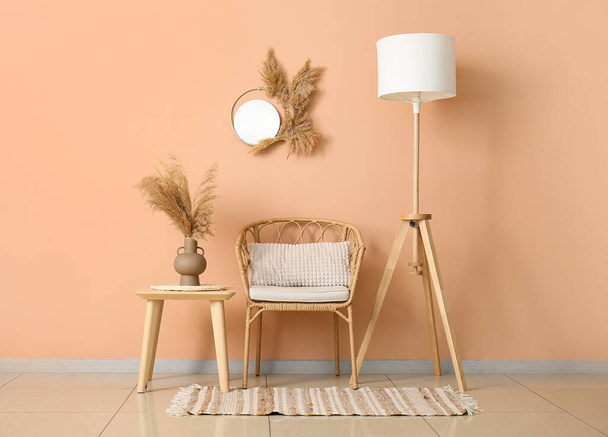 Интерьер стильной гостиной с плетеным стулом, столом и стандартной лампой - Фото, изображение