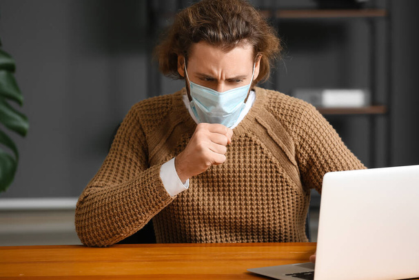 Uomo malato che indossa una maschera medica in ufficio - Foto, immagini