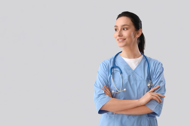 Portrait of female doctor on grey background - Photo, Image