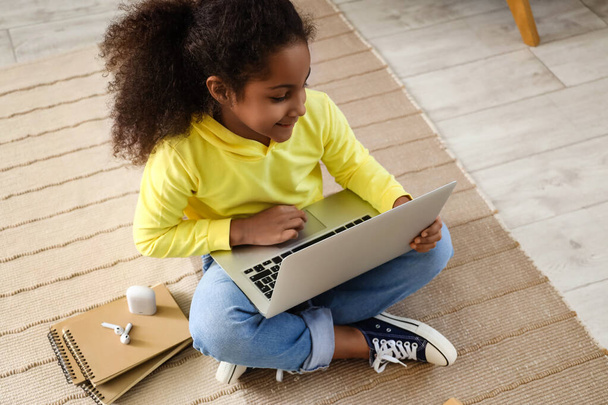 Mała Afroamerykanka ucząca się z nauczycielem online na podłodze w domu - Zdjęcie, obraz