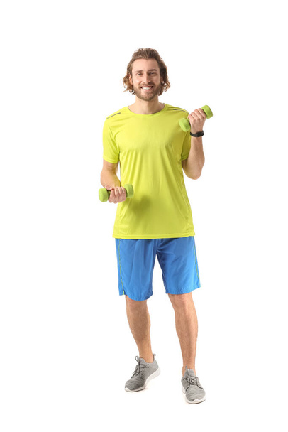 Sporty man with dumbbells on white background - Фото, изображение