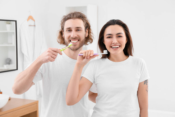 Banyoda dişlerini fırçalayan güzel bir çift. - Fotoğraf, Görsel