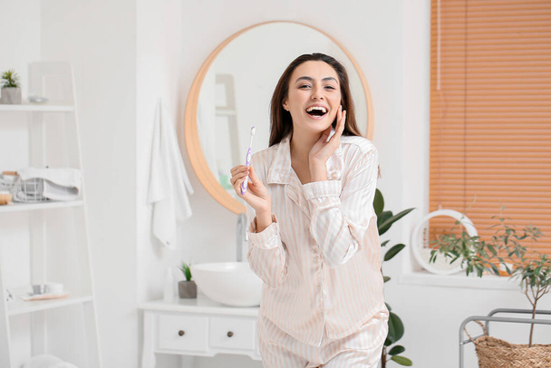 Felice giovane donna con spazzolino da denti in bagno
 - Foto, immagini