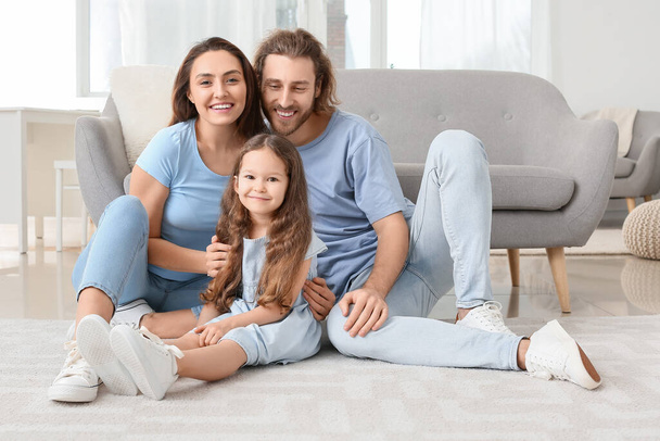 若い家族は家で柔らかいカーペットの上に座っている - 写真・画像