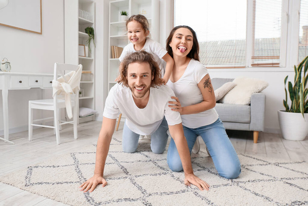 Щаслива молода сім'я на килимі вдома
 - Фото, зображення