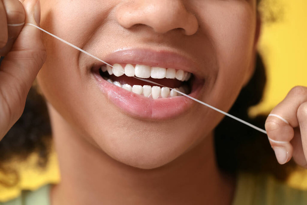 afro-americano adolescente menina fio dental dentes no amarelo fundo, close-up - Foto, Imagem