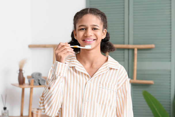Αφροαμερικανή έφηβη που βουρτσίζει τα δόντια της στο μπάνιο - Φωτογραφία, εικόνα
