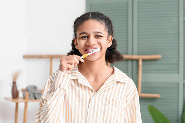 Afroamerykanka nastolatka mycie zębów w łazience - Zdjęcie, obraz