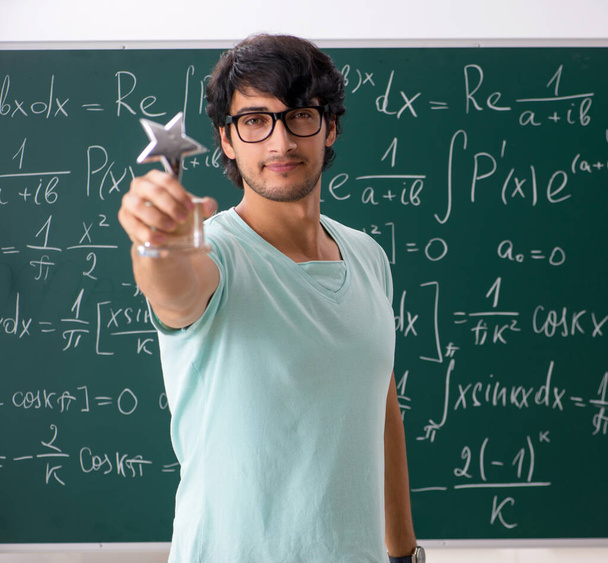 Jonge mannelijke student wiskundige voorkant schoolbord - Foto, afbeelding