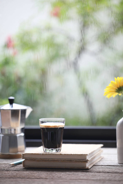 Egy csésze kávé és egy fazék az ablak előtt. - Fotó, kép