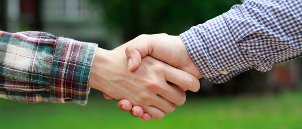 Closeup of a business hand shake between two colleagues Plaid shirt - Фото, зображення