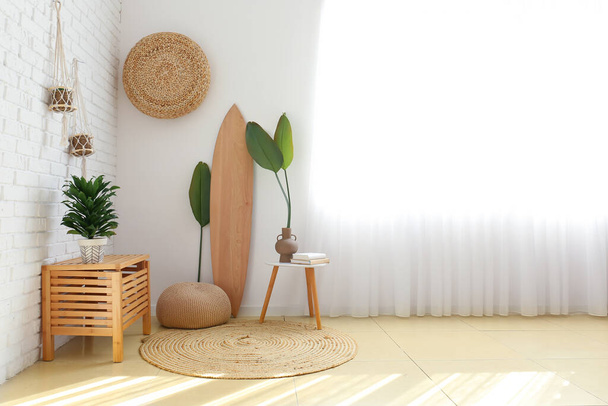 Interno della stanza luminosa con tavola da surf in legno e piante d'appartamento - Foto, immagini