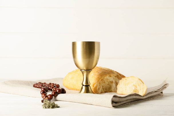 Xícara de vinho com pão e rosário sobre fundo de madeira branca - Foto, Imagem