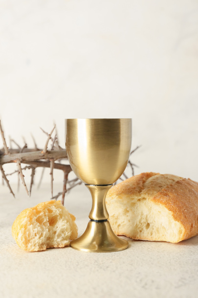 Cup of wine with bread and crown of thorns on light background - Photo, Image