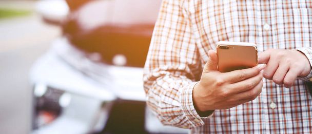 close up businessman hand using a mobile smart phone call a car mechanic ask for help assistance because car broken roadside. people journey friends standing wait beside broken car background. - Photo, image