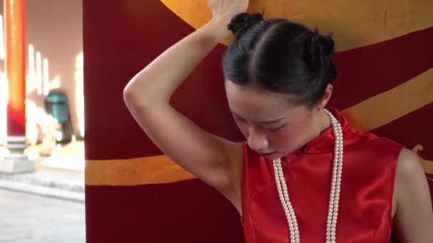 Γυναίκα σε κόκκινο παραδοσιακό κινέζικο κόκκινο κοστούμι ποζάρει για φωτογράφηση. - Πλάνα, βίντεο