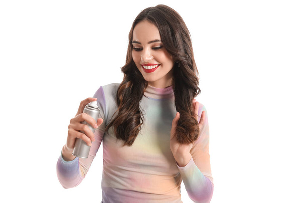 Jolie jeune femme avec spray capillaire isolé sur blanc - Photo, image