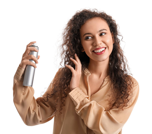Pretty young African-American woman with hair spray on white background - Photo, Image