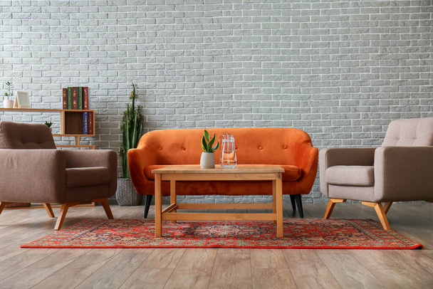 Інтер'єр затишної вітальні з вінтажним килимом, диваном і кріслами
 - Фото, зображення