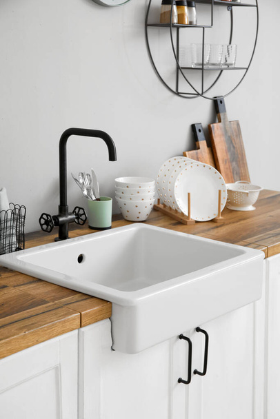 Counters with ceramic sink, kitchen utensils and food near light wall - Foto, Imagem