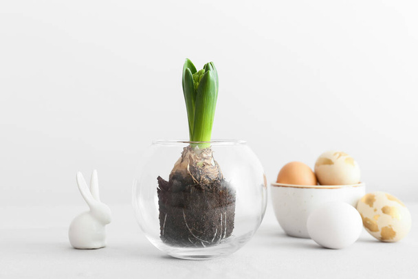 Güzel sümbül bitkisi, Paskalya yumurtası ve arka planda tavşan olan cam kap. - Fotoğraf, Görsel