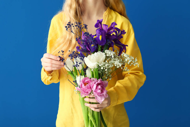 ブルーの背景に美しい花束を持っている女性 - 写真・画像