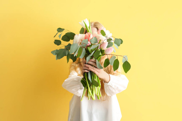 Young woman holding beautiful flowers on color background - Photo, Image