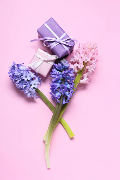 Hermosas flores de jacinto y cajas de regalo sobre fondo rosa - Foto, imagen