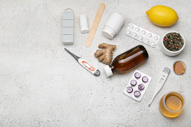Medikamente gegen Halsschmerzen, Zitrone, Honig und Thermometer auf hellem Hintergrund - Foto, Bild