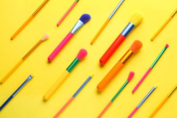 Set of colorful makeup brushes on yellow background - Photo, Image