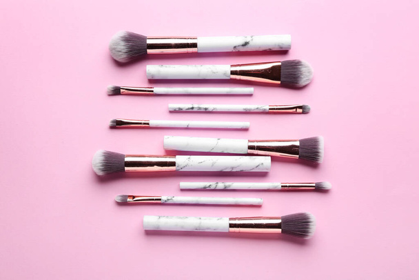 Set of makeup brushes on pink background, top view - Photo, Image