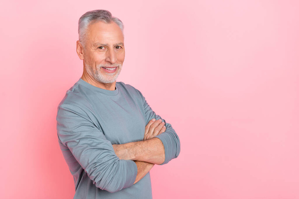 Photo of cute charming man pensioner dressed grey shirt empty space arms crossed isolated pink color background - Foto, immagini